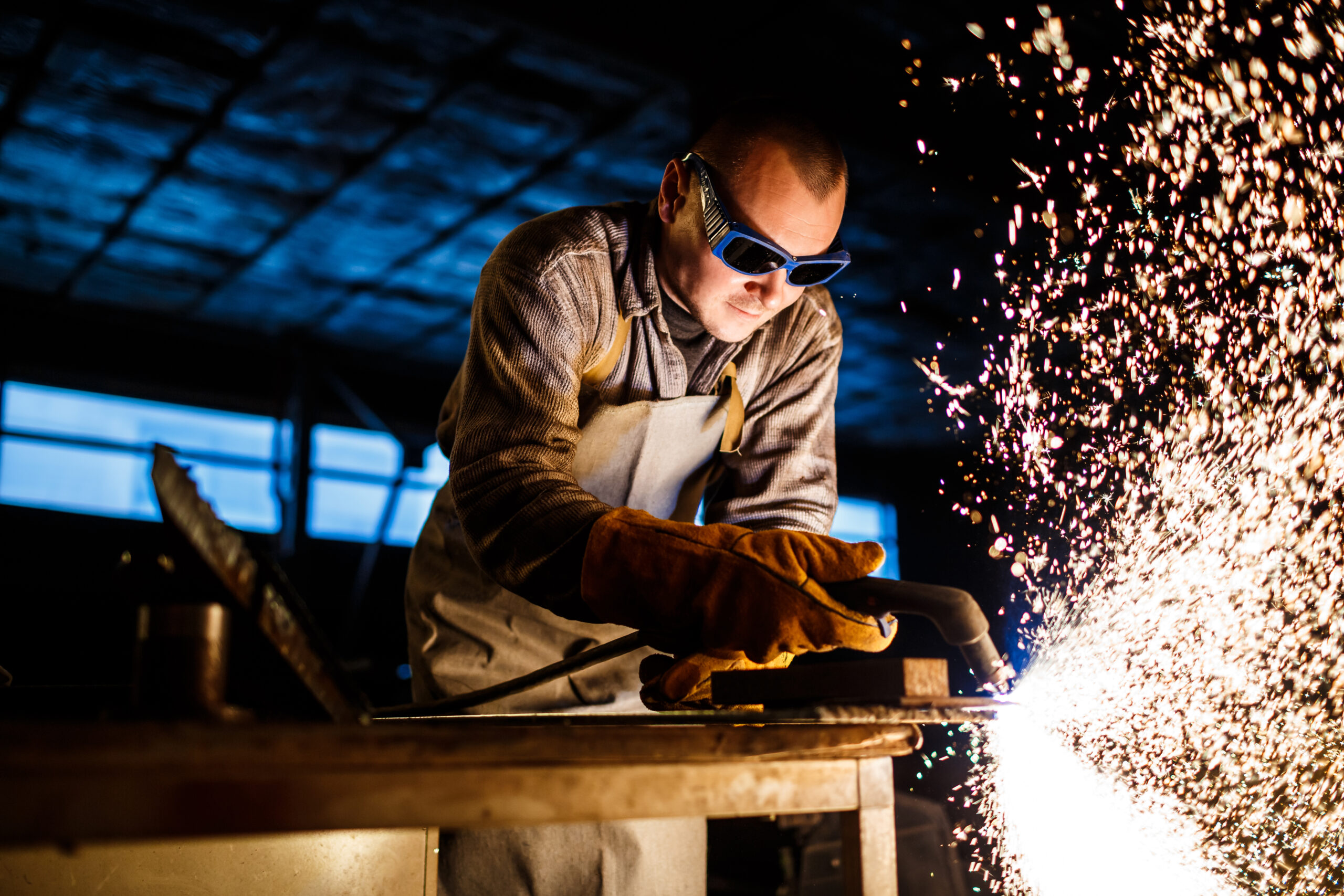 Worker cutting metal with plasma equipment on plant.